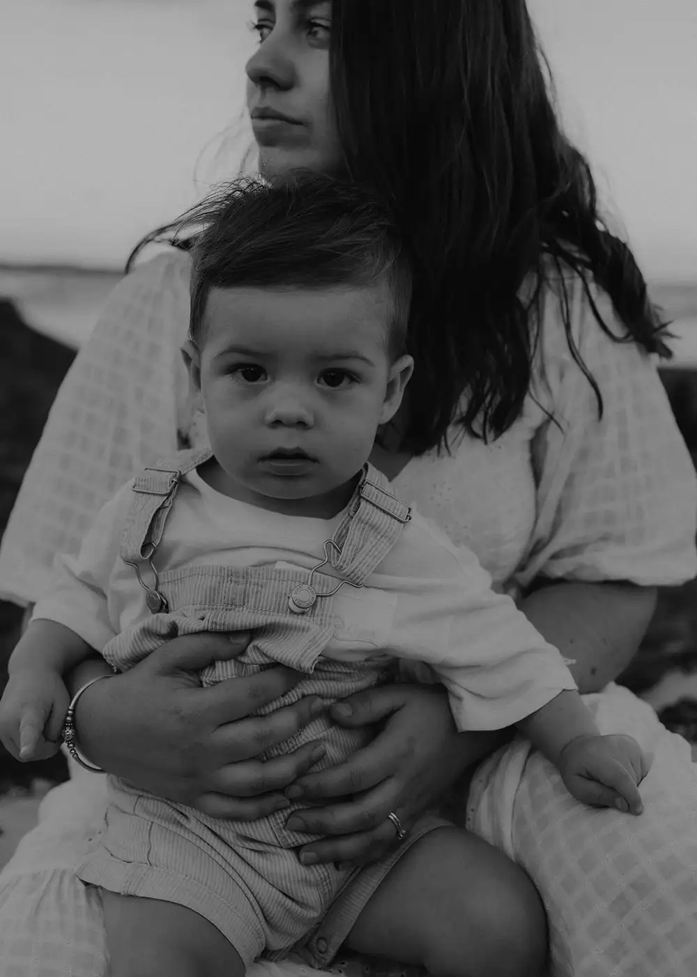 Black and white portrait of a baby sitting on a woman's lap