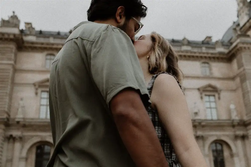 Couple sharing a kiss outside a historic building