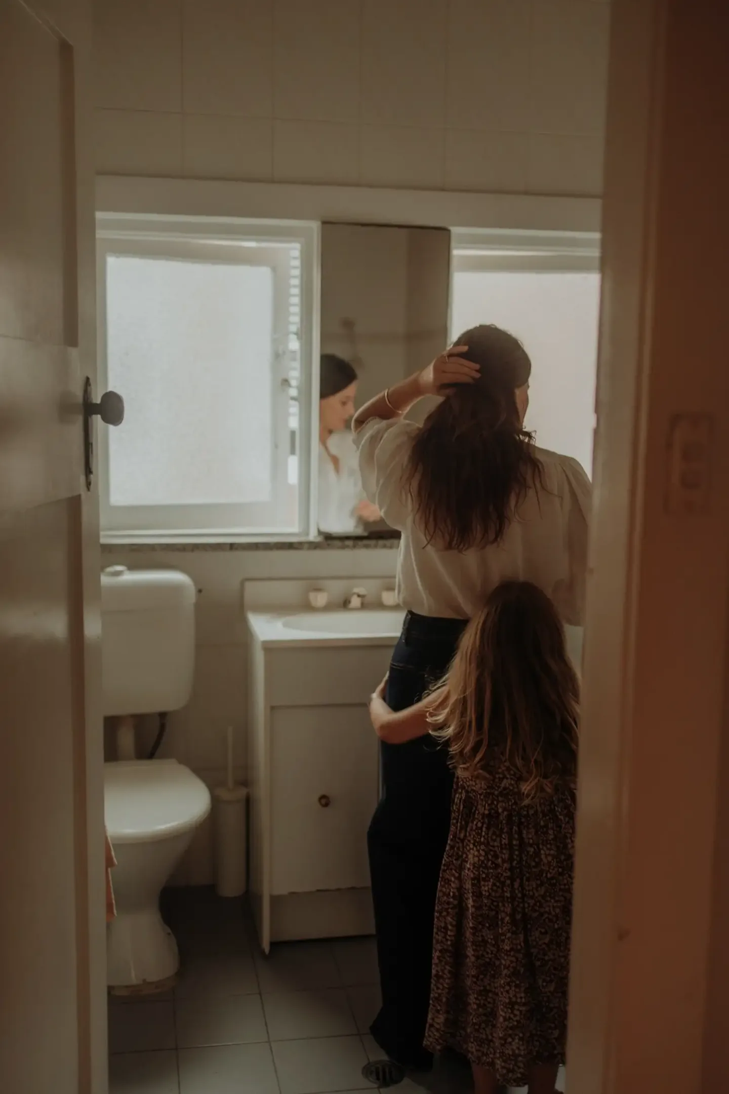 Woman holding a baby in a doorway at home